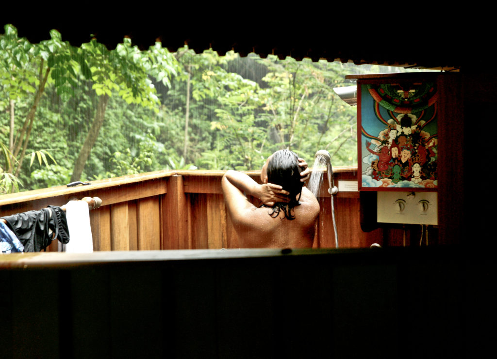 Experiencing the bliss of an outdoor shower in the jungle while it rains in Thailand.